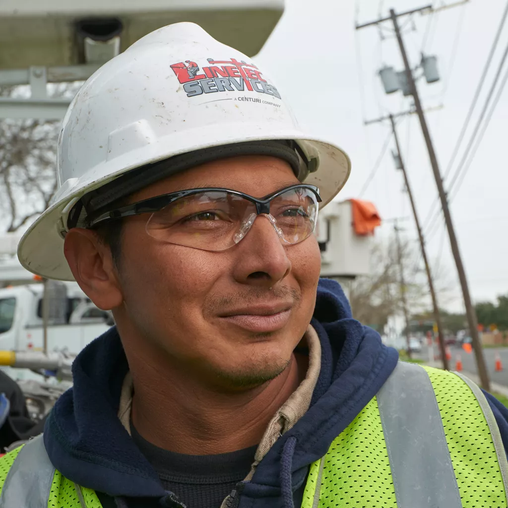 A Linetec worker smiles wearing a hard hat and safety goggles in Corpus Christi, Texas.