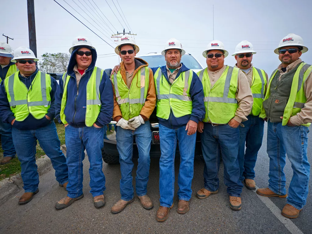 A team of Linetec workers stands in a group smiling.