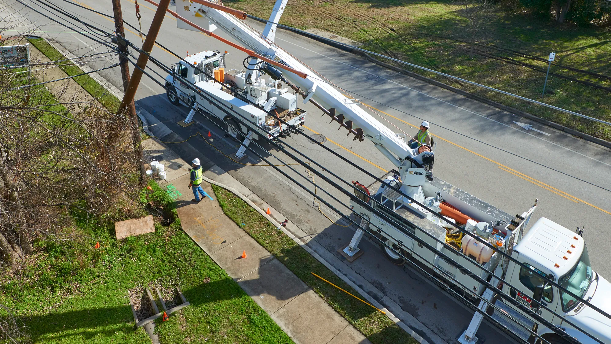 Linetec workers in hard hats and safety goggles work on downed power lines in San Marcos Texas.