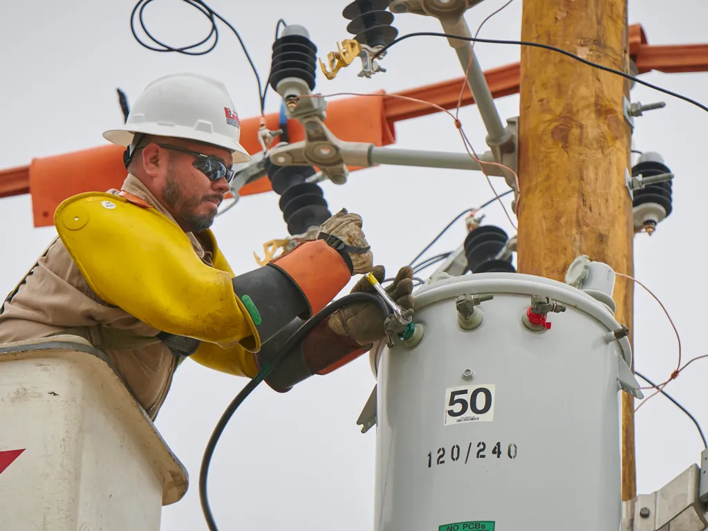 A Linetec worker uses tools on power lines in Laredo Texas.